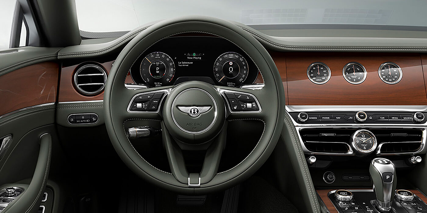 Bentley Monterrey New Bentley Flying Spur sedan front cabin in Cumbrian Green hide and Crown Cut walnut veneer showing steering wheel and Rotating Display with three clocks on face