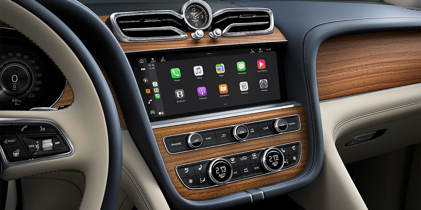 Bentley Monterrey Bentley Bentayga EWB Azure dashboard in Open Pore Koa veneer featuring multimedia screen and climate control console.